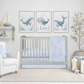 A styled nursery scene with a light gray wooden crib, pale blue bedding, and three framed whale prints above the crib. The prints include the name Leo and are shown in a real room setting with a chair, shelf, basket, and plant.

Baby Boy Crib Bedding Light Blue - The Creative Raccoon 