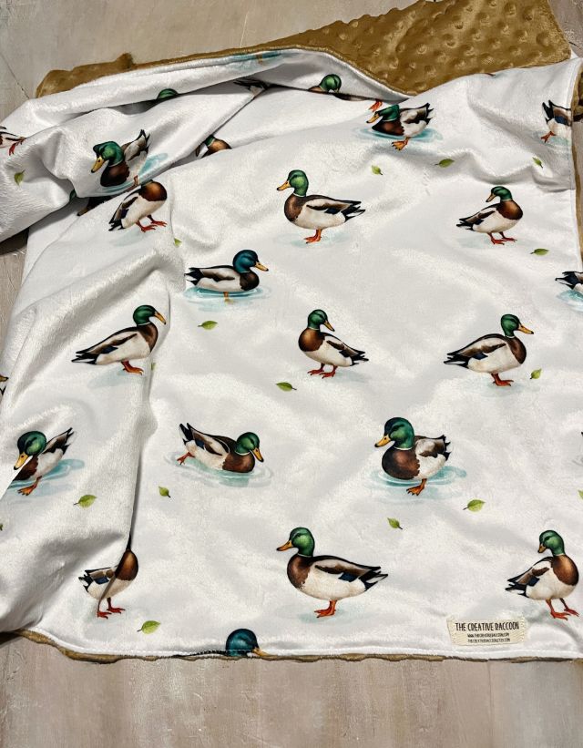 Baby wrapped in a blanket with 'Emerson' embroidered on a blanket with mallard ducks. Mallard Duck Baby Blanket - The Creative Racoon