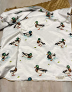 Baby wrapped in a blanket with 'Emerson' embroidered on a blanket with mallard ducks. Mallard Duck Baby Blanket - The Creative Racoon