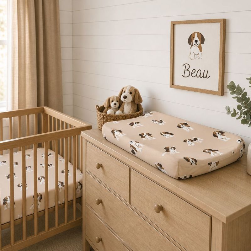A baby nursery scene with a wooden crib and changing dresser. The changing pad on the dresser has a beige background with a repeating brown and white puppy print.
Beagle Crib Sheet - The Creative Raccoon