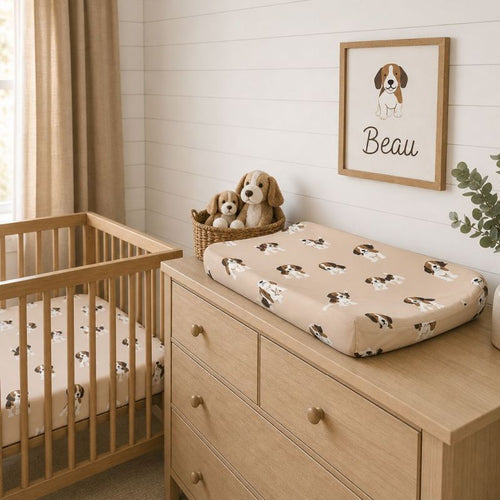 A baby nursery scene with a wooden crib and changing dresser. The changing pad on the dresser has a beige background with a repeating brown and white puppy print.
Beagle Crib Sheet - The Creative Raccoon