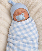 Baby wearing a solid light blue knot hat and wrapped in a light blue and white checkered swaddle