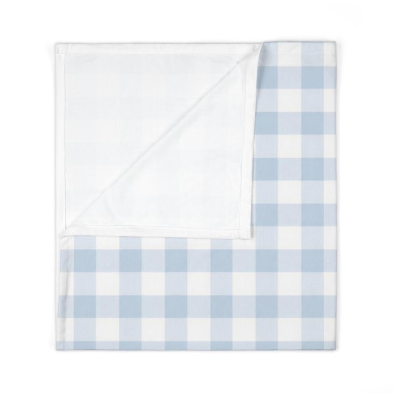 A folded baby blanket featuring a light blue and white gingham check pattern on one side and a solid white plush backing on the other, shown on a clean white background.