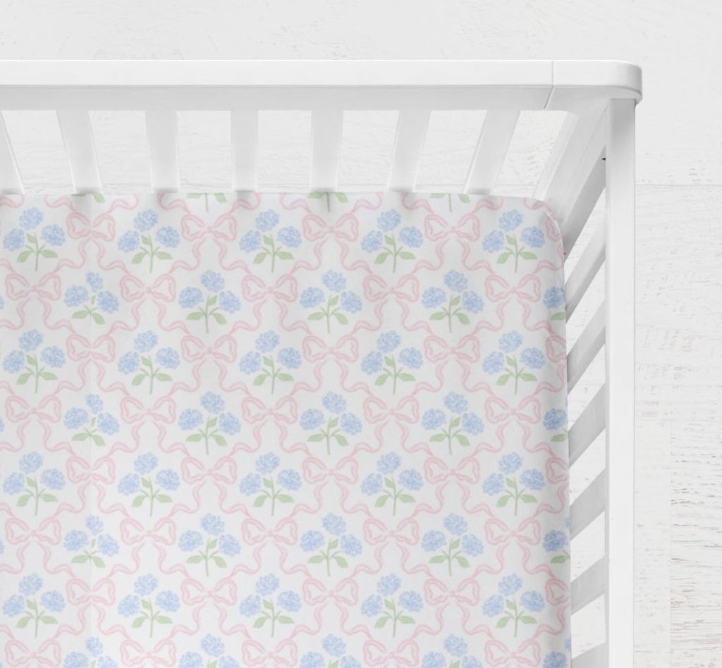 cotton fitted crib sheet featuring a delicate blue hydrangea bouquet accented by a pink bow
Blue Hydrangea Pink Bow Crib Sheet - The Creative Raccoon