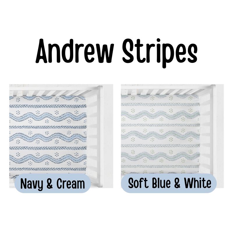 Two crib mattress or bedding style options labeled 'Andrew Stripes' on a white background. Left option reads 'Navy & Cream' and shows a white crib insert with navy wavy stripes and small motifs. Blue & White Crib Sheets - The Creative Raccoon - Andrew Stripes