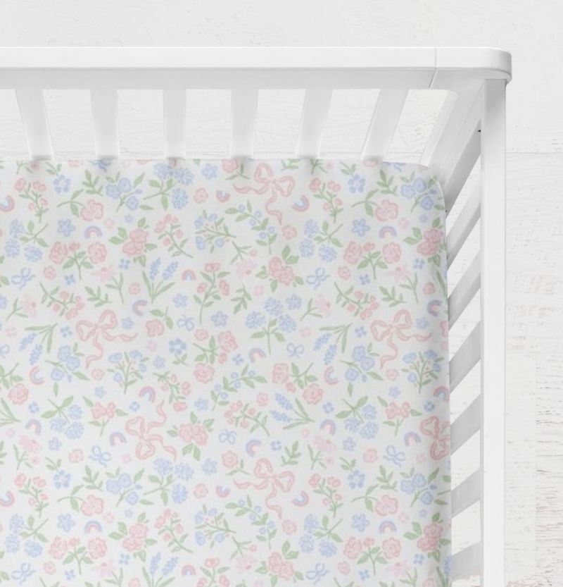 Floral patterned crib sheet on a white crib.
Bow Crib Sheet - The Creative Raccoon