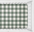 A fitted crib sheet with a green and white gingham check pattern, shown inside a white wooden crib. Crib Sheet - Dark Sage gingham - The Creative Raccoon