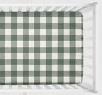 A fitted crib sheet with a green and white gingham check pattern, shown inside a white wooden crib. Crib Sheet - Dark Sage gingham - The Creative Raccoon
