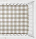A fitted crib sheet with a classic brown and white gingham check pattern, shown inside a white wooden crib. Khaki Gingham Crib Sheet 2 inch squares - The Creative Raccoon
