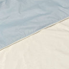 A close-up of a light blue baby blanket with soft plush white minky showing the texture and stitching.
Light Baby Blue Cotton Baby Blanket - The Creative Raccoon 