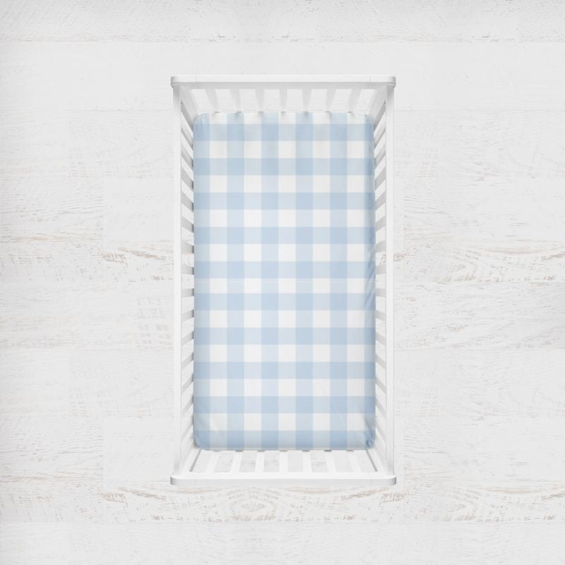 Crib with a blue and white checkered sheet on a light gray background
Light Blue Gingham Crib Sheet - The Creative Raccoon