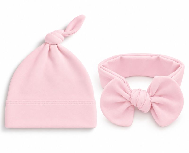 A baby accessory set featuring a soft pink knotted beanie hat and a matching pink bow headband, displayed on a clean white background.