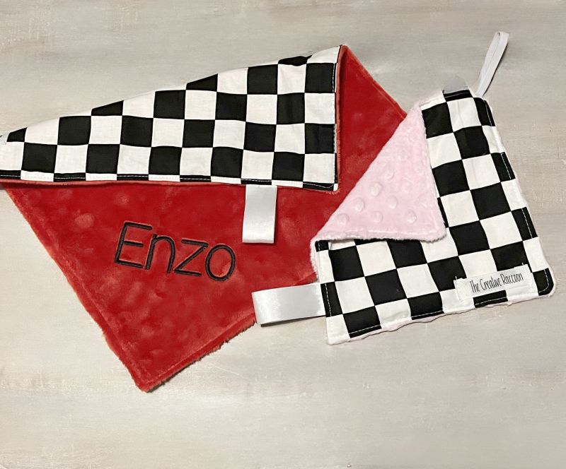 Checkered lovey mini blanket with 'Enzo' embroidery on the red minky back side & paci blanket with elastic loop for a pacifier on a neutral background. 
Softest Minky Security Lovey - The Creative Raccoon