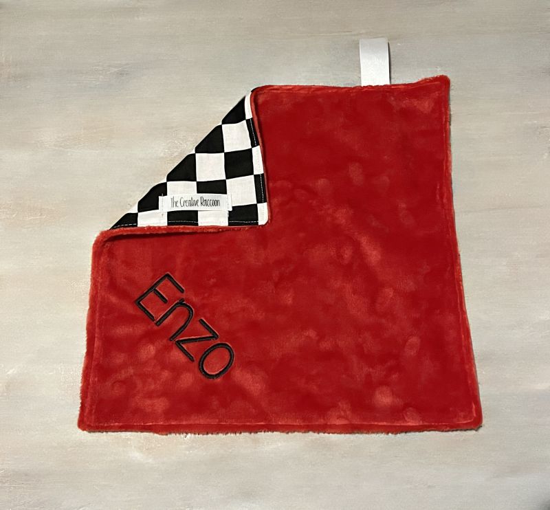 Lovey blanket shown with red minky backing, satin ribbon loop, checkered top, embroidered with "Enzo". 
Softest Minky Security Lovey - The Creative Raccoon