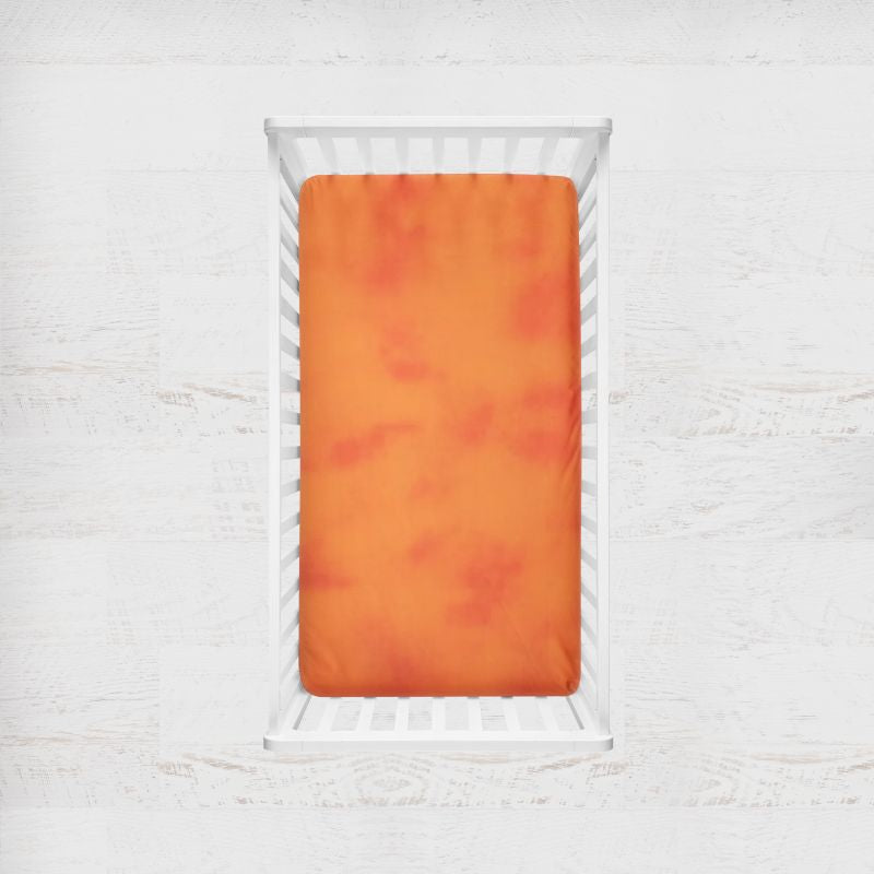 Orange fitted sheet on a white crib with a light gray background. orange mango blender crib sheet - the creative raccoon